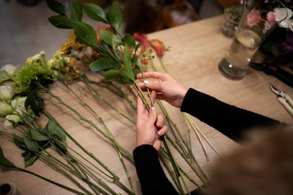 vrouw maakt kunstbloemen boeket