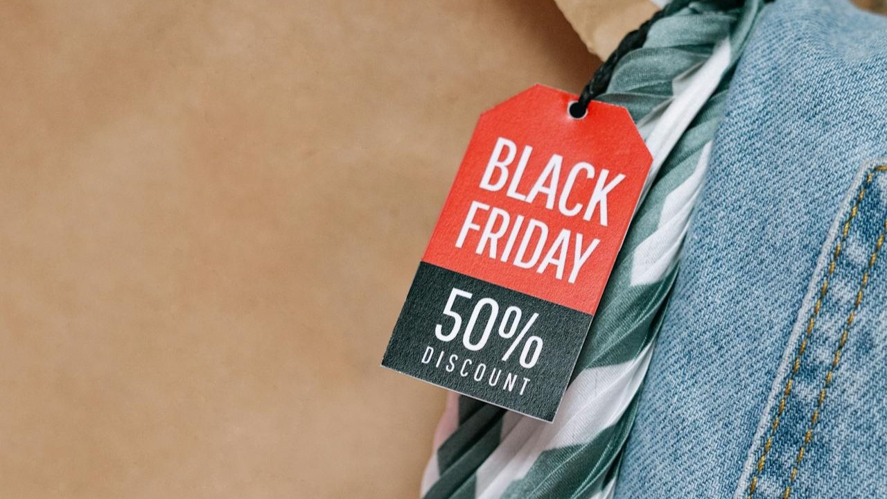 Label met 'Black Friday 50% discount' aan een kledingstuk met denim en groene accenten