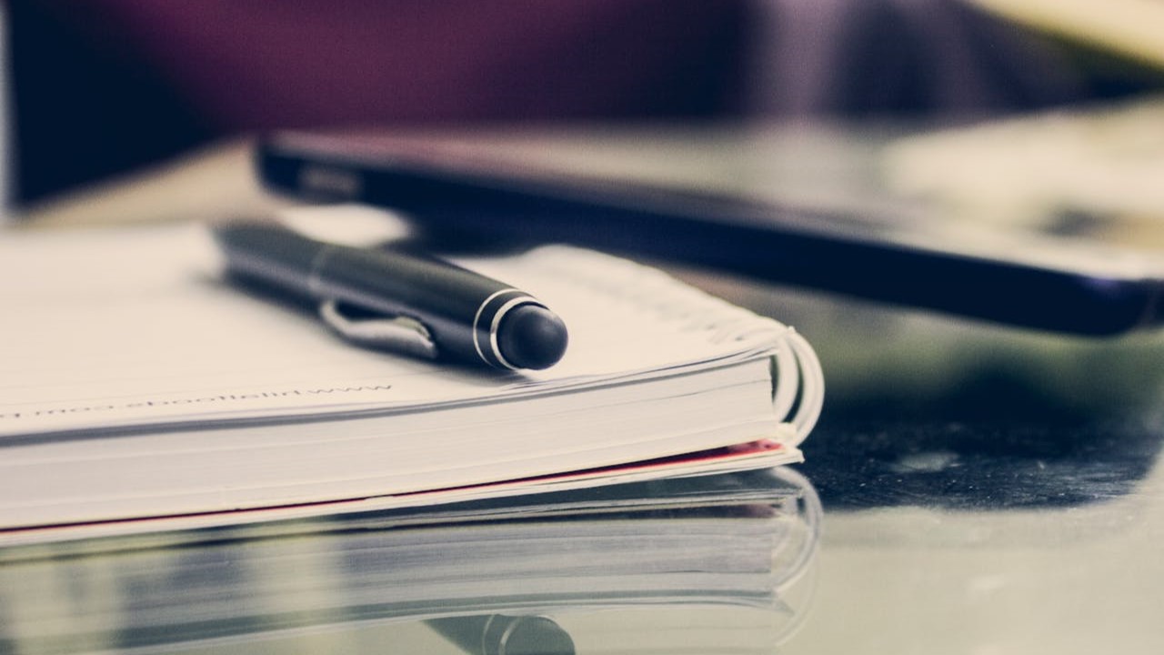 Pen op een opengeslagen notitieboek, klaar voor het starten van een VOG-aanvraag