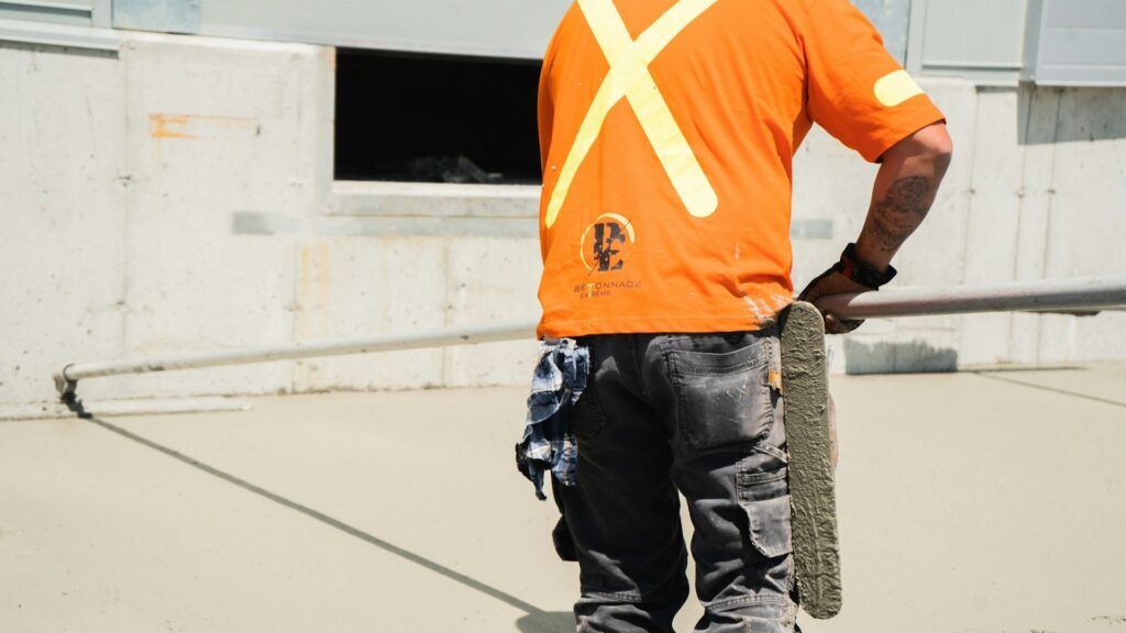 Werker strijkt vers gestorte vloer glad, belangrijk voor goede vloer rusttijd