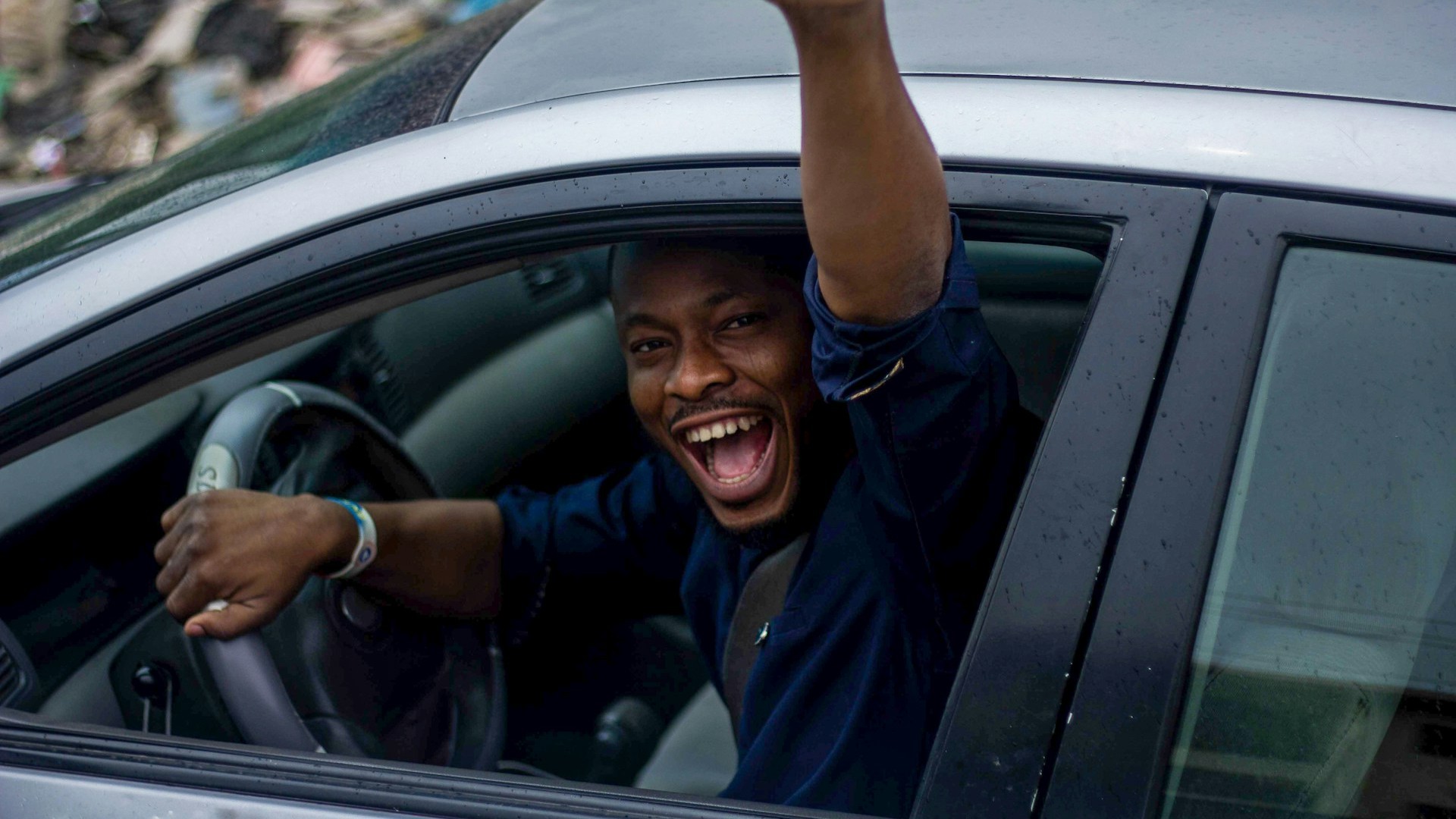 Geslaagde leerling viert behalen van spoedcursus rijbewijs vanuit de auto